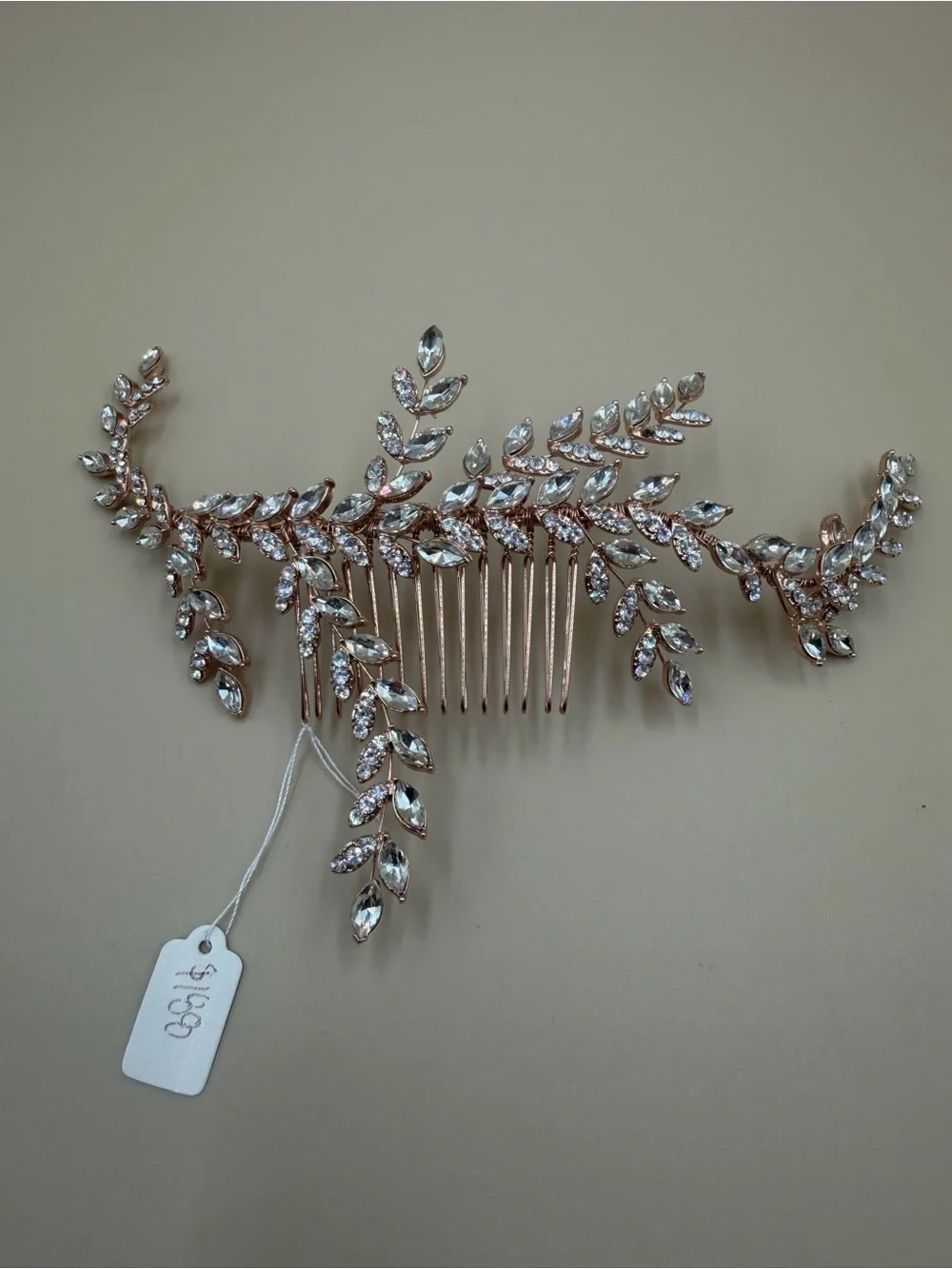 Elegant rose gold-tone bridal hair comb featuring a cascading leaf-and-vine desi